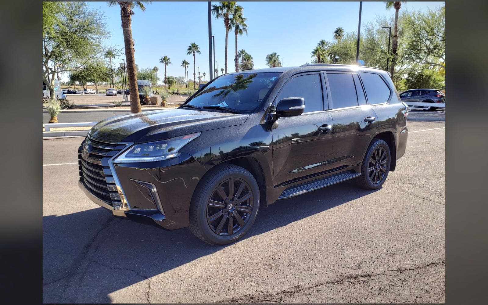 Black Lexus LX-class flagship 4x4 photographed in bright sunlight