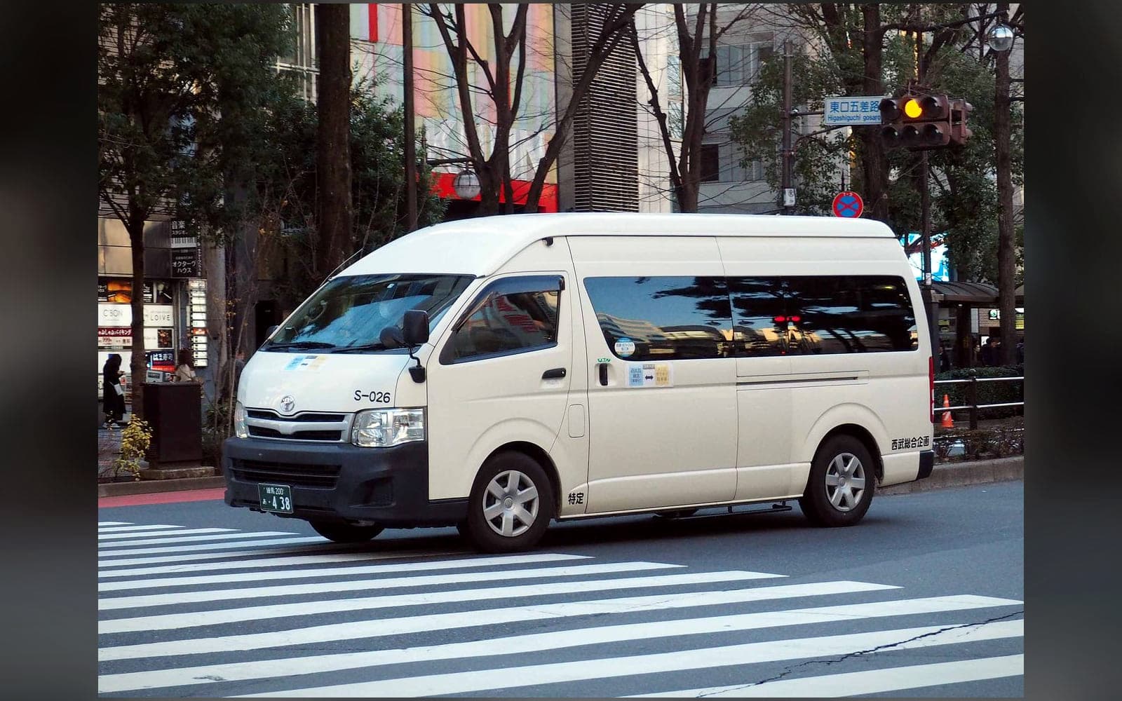 White high-roof Toyota Hiace Commuter — the thirteen-seat Grand Cabin class — in side profile